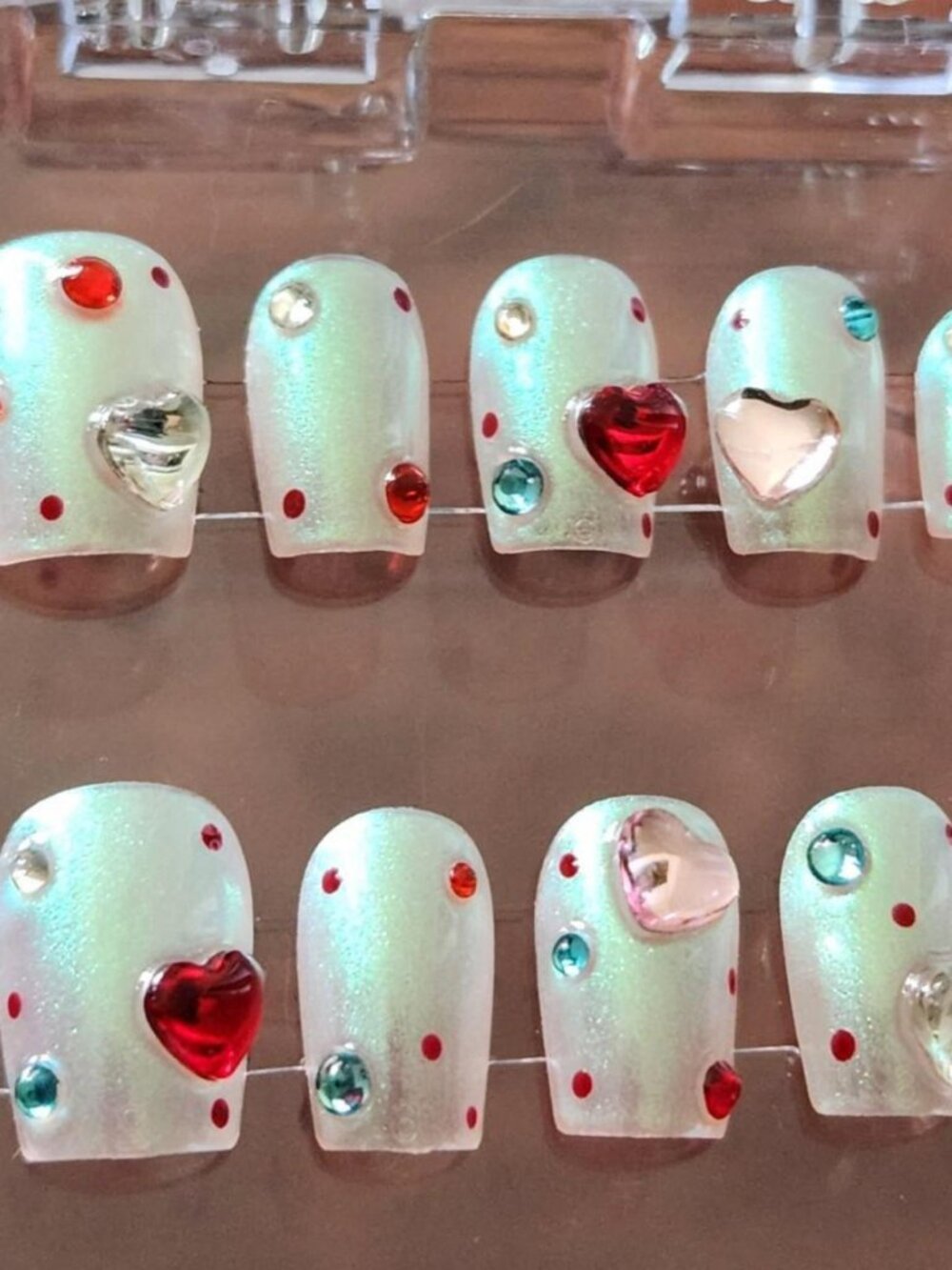 1.5 short pearlescent white press-on nails with heart-shaped gems. Size Small.